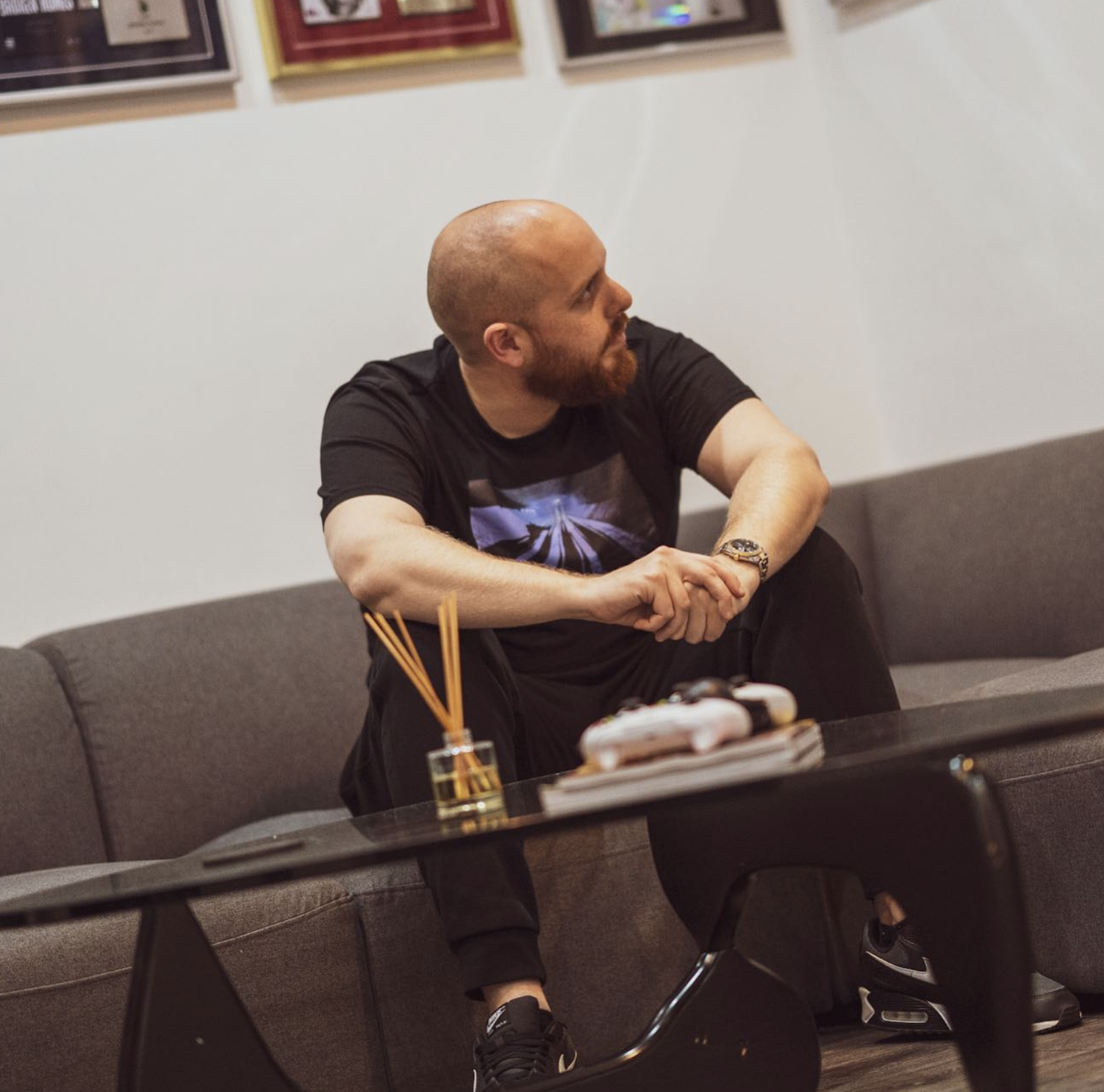 Sean D seated beneath framed records
